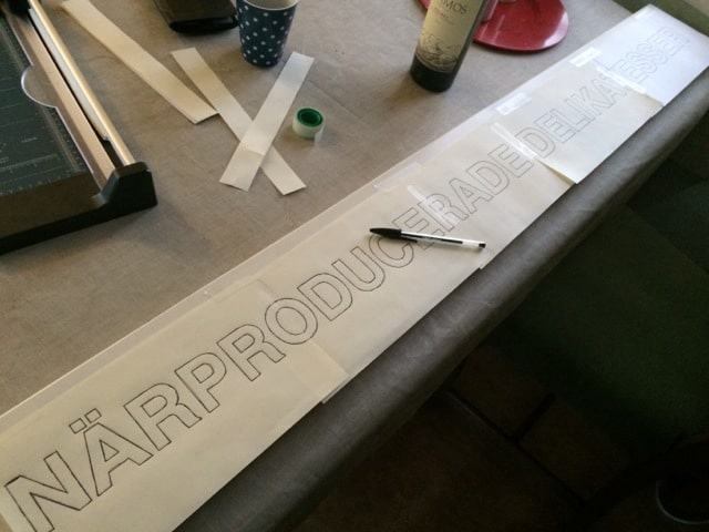 En gammal planka, målarfärg, karbonpapper och en pensel – sen kan man göra sin egen skylt.
